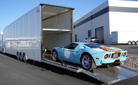 Enclosed car transport trailer showing modern methods of logistics and supply chain management.