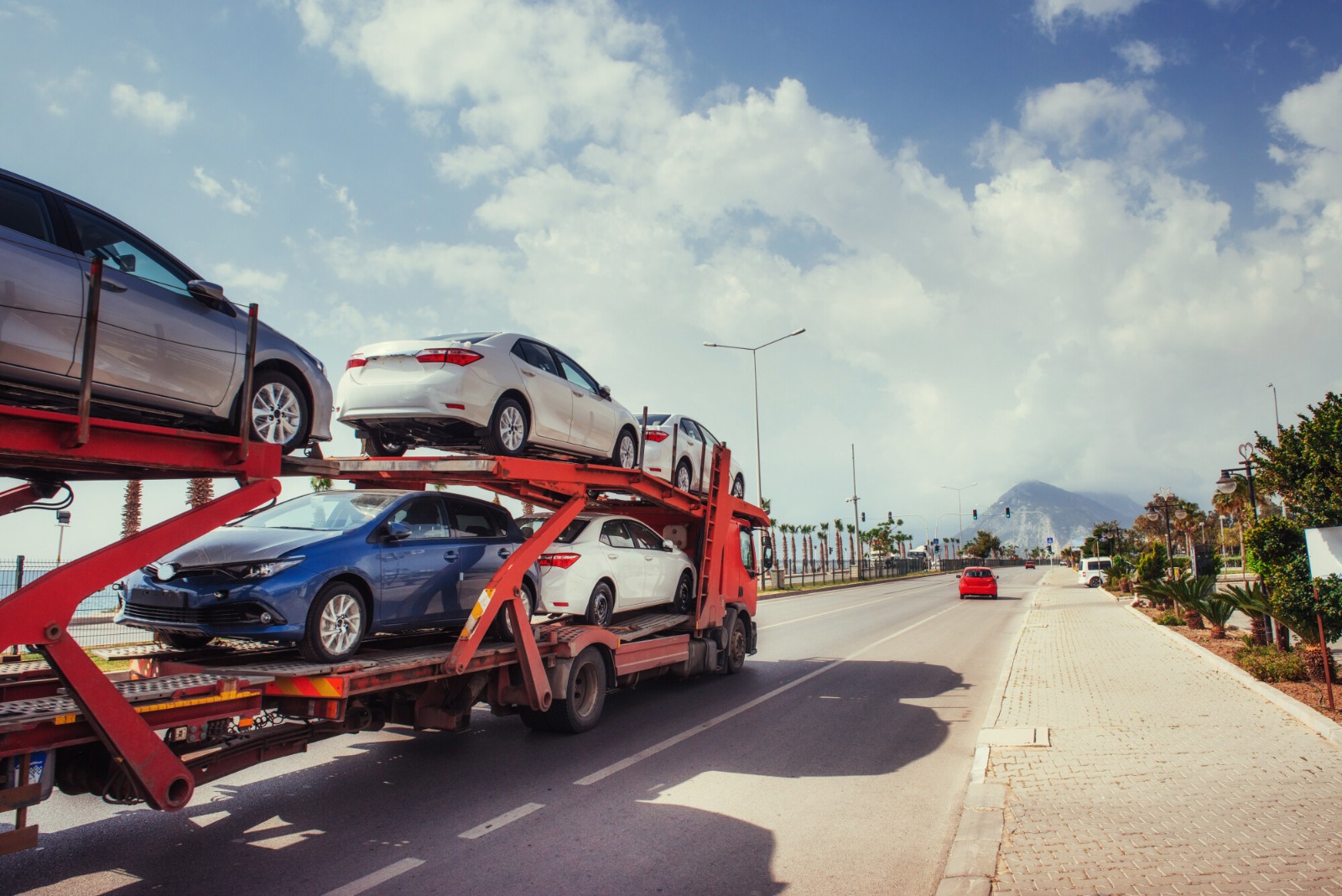 Car carrier on highway transporting sedans – A Complete Guide to Automobile Shipping.
